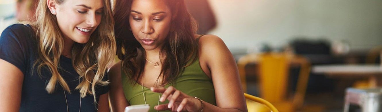 Two women looking at a cellphone screen together